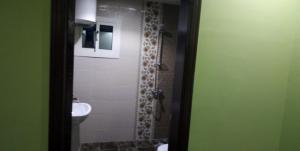a bathroom with a shower with a sink and a toilet at Kol Alayam Hotel in Makkah