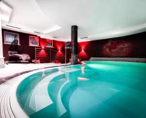a large swimming pool in a room with red walls at Hotel Lärchenhof in Kaunertal
