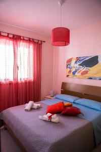 una camera con 2 letti singoli e tende rosse di Casa Vacanze Soledad a Marina di Ragusa