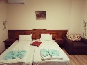 a bedroom with a bed and a couch at Guest House Nani in Asenovgrad