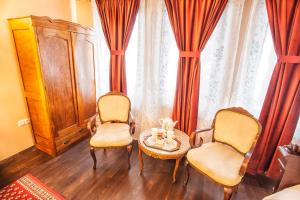 ein Wohnzimmer mit zwei Stühlen und einem Tisch in der Unterkunft Hotel Evmolpia in Plowdiw