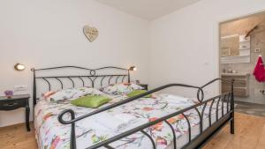 sypialnia z metalowym łóżkiem z zielonymi poduszkami w obiekcie Villa Mia with heated pool, billiards and large garden - by TA Leut Agency w mieście Privlaka +25 zdjęć