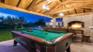 część rozrywkowa na świeżym powietrzu ze stołem bilardowym i kominkiem w obiekcie Villa Mia with heated pool, billiards and large garden - by TA Leut Agency w mieście Privlaka