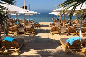 un grupo de sillas y sombrillas en una playa en Kasta Beach Hotel, en Ofrinion