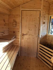 un sauna vide avec des murs en bois et une porte dans l'établissement Oberprantschöllhof - Horse Mountain Stable, à Bressanone