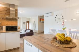 kuchnia ze stołem z miską bananów w obiekcie Villa Mia with heated pool, billiards and large garden - by TA Leut Agency w mieście Privlaka
