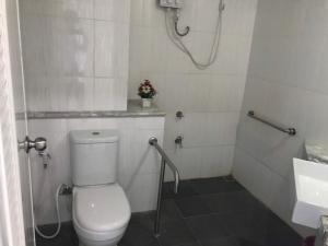 a bathroom with a toilet and a shower and a sink at Like Residence in Suratthani