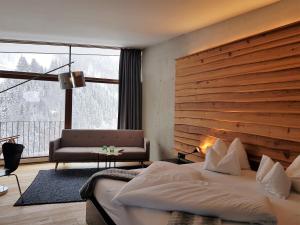 a bedroom with a large bed and a large window at "Quality Hosts Arlberg" Hotel Lux Alpinae in Sankt Anton am Arlberg