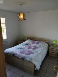 a bedroom with a bed with a floral bedspread at CHEZ MARTINE Appt climatisé 2 Chambres in Capbreton