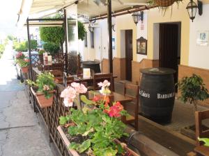 a restaurant with flowers and tables and a barrel at Caico's in Prado del Rey