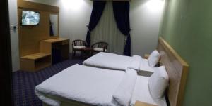 Habitación con 2 camas en una habitación de hotel en Kol Alayam Hotel, en La Meca