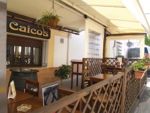 un restaurante con mesas y sillas y un cartel que lee casos en Caico's en Prado del Rey
