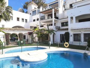 a swimming pool in front of a building at Elegant apartment in Puerto Banus in Marbella