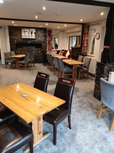 a dining room with wooden tables and chairs at Y Giler Arms in Pentrefoelas