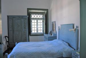 Prédio na Amêndoa في Amêndoa: غرفة نوم بسرير ازرق ونافذة