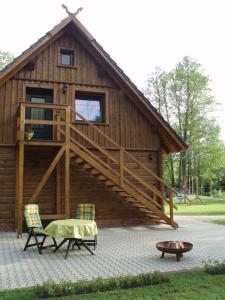 een groot houten gebouw met een terras en een bank bij Ferienwohnung Wasserlilie in Kolonie