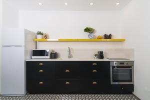 a kitchen with a sink and a refrigerator at Mr. Brooklyn - By TLV2GO in Tel Aviv