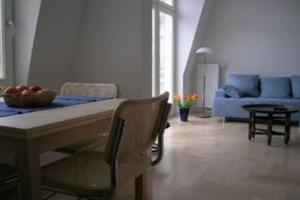 ein Wohnzimmer mit einem Tisch und einem blauen Sofa in der Unterkunft Villa Quisisana in Ahlbeck