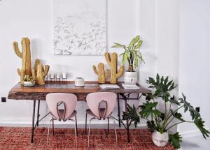 a dining room table with pink chairs and a cactus at Mana EcoRetreat in Las Breñas
