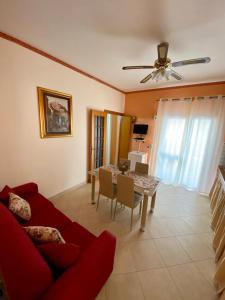 a living room with a red couch and a table at Appartamento La Sicula in Realmonte