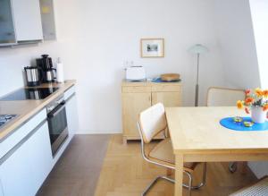 eine Küche mit einem Tisch, Stühlen und einem Tisch sowie eine Küche mit einer Küche in der Unterkunft Villa Quisisana in Ahlbeck