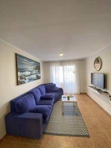 sala de estar con sofá azul y mesa en Casa Candelaria, en Candelaria