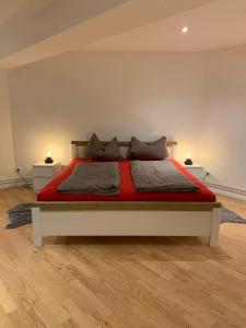 1 dormitorio con 1 cama con sábanas y almohadas rojas en Sacco 7, en Birkenwerder