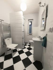 uma casa de banho com piso em xadrez preto e branco em Apartments by the beach em Trzebiez