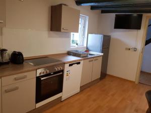 a kitchen with a stove and a refrigerator at LMI Haus & Urlaub Monteurwohnungen 2 in Münsingen