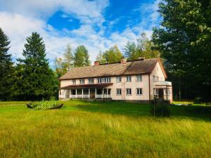 a large white house in a field of grass at Olo Center by Kolovesi Nature Park in Enonkoski