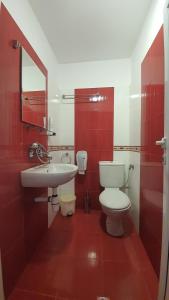 - une salle de bains rouge et blanche avec toilettes et lavabo dans l'établissement Семеен Хотел-Ресторант Етно Чакала, à Sevlievo