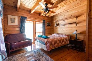 a bedroom with a bed and a couch in a log cabin at PRIVATE Log Cabin with Indoor pool sauna and gym YOU RENT IT ALL NO ONE ELSE in McAlpin +102 photos