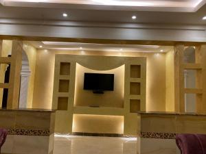 a living room with a tv on a wall at Durat Al Ruwmansiya 3 in Tabuk