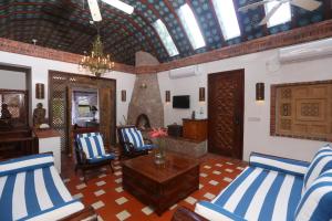 a living room with blue and white chairs and a fireplace at Caille Blanc Villa & Hotel in Soufrière