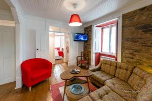 - un salon avec un canapé et un fauteuil rouge dans l'établissement Casa do Silverio - Barroca, à Barroca