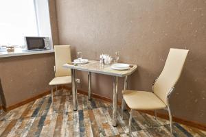 a table in a room with two chairs and a table with a plate at PaulMarie Apartments on Mira 25B in Mogilev