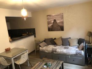 a living room with a bed and a table at Le Paillot de Montabert in Troyes