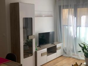 a living room with a tv on a white cabinet at New, cozy apartment Plaza del Pilar-Fuenclara in Zaragoza