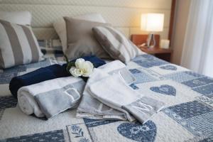 Una cama con toallas y una flor. en Beverly Park Residence, en Tirrenia