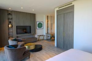 Views Hotel & Residences في King Abdullah Economic City: غرفة بسرير وغرفة معيشة مع تلفزيون