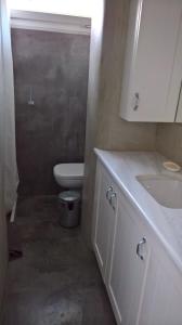 une salle de bain blanche avec toilettes et lavabo dans l'établissement Under the Acropolis, tiny room, big terrace, à Athènes