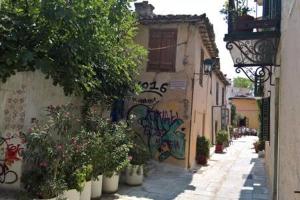 Une allée avec graffiti sur le côté d'un bâtiment dans l'établissement Under the Acropolis, tiny room, big terrace, à Athènes