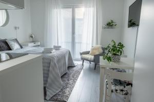 a white room with a bed and a kitchen at Compact high quality top floor studio in perfect location in Oulu
