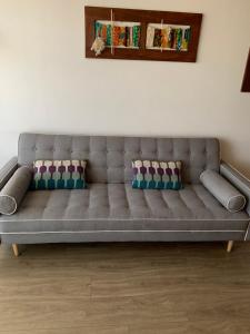 a gray couch in a living room with pillows at Selma Apartment in Santiago