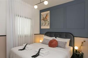 sypialnia z łóżkiem z białą pościelą i poduszkami w obiekcie Mr. Brooklyn - By TLV2GO w Tel Awiwie