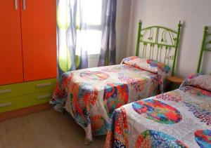 濱海羅克塔斯的住宿－Precioso piso en Roquetas de Mar，一间带两张床和梳妆台的卧室
