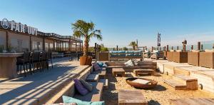 a patio with couches and tables and a building at Sunset Lodge in Zandvoort