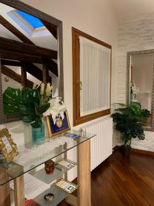 Casa Jaqueline ( Attico ) في البندقية: غرفة مع طاولة زجاجية ومرآة