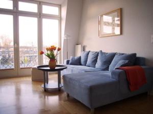 ein Wohnzimmer mit einer blauen Couch und einem Tisch in der Unterkunft Villa Quisisana in Ahlbeck