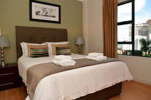 a bedroom with a large bed with towels on it at WeStay Westpoint Apartments in Johannesburg